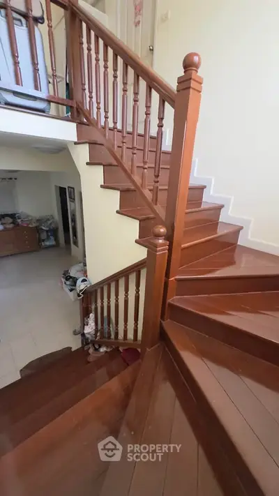 Elegant wooden staircase in a modern home with polished finish and stylish railing.
