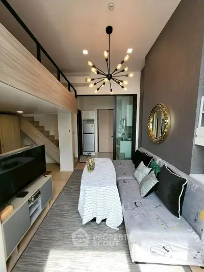 Modern living room with loft, stylish chandelier, and cozy decor