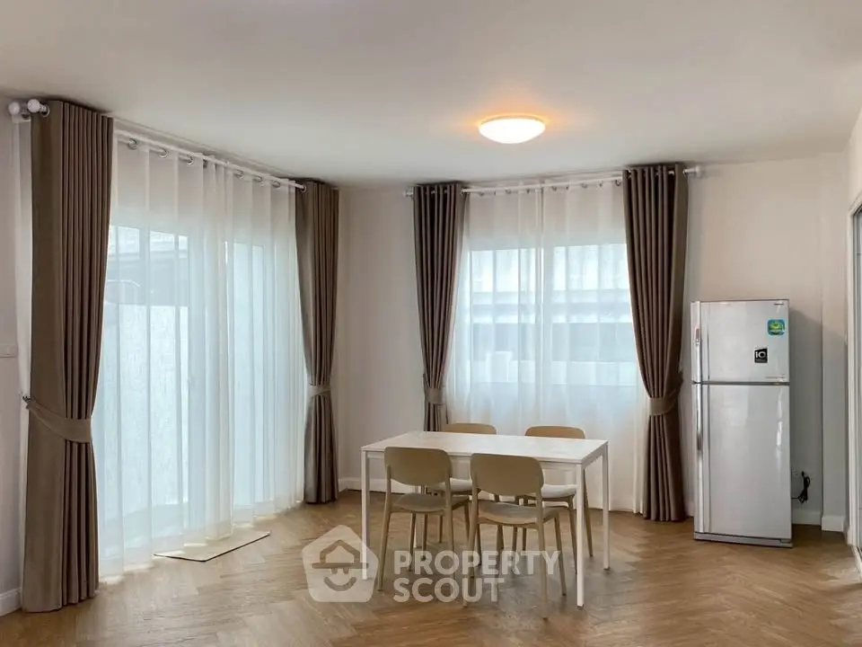 Bright dining area with modern table, chairs, and large windows in a stylish apartment.