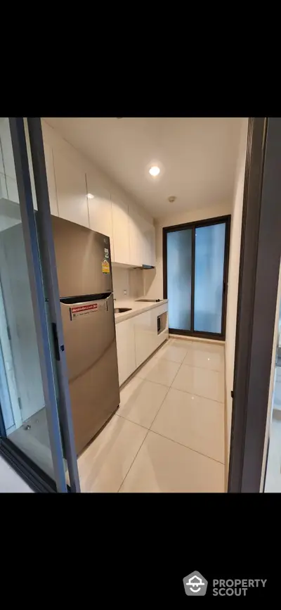 Modern kitchen with sleek cabinetry and stainless steel appliances in a compact layout.