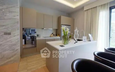 Modern kitchen with sleek cabinetry and island, featuring elegant decor and natural light.
