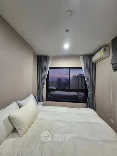Cozy bedroom with large window and city view, featuring modern air conditioning and elegant curtains.