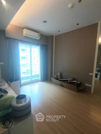 Spacious unfurnished room with large window and wooden flooring