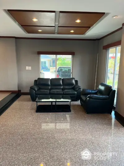 Spacious living room with modern leather sofa and large windows