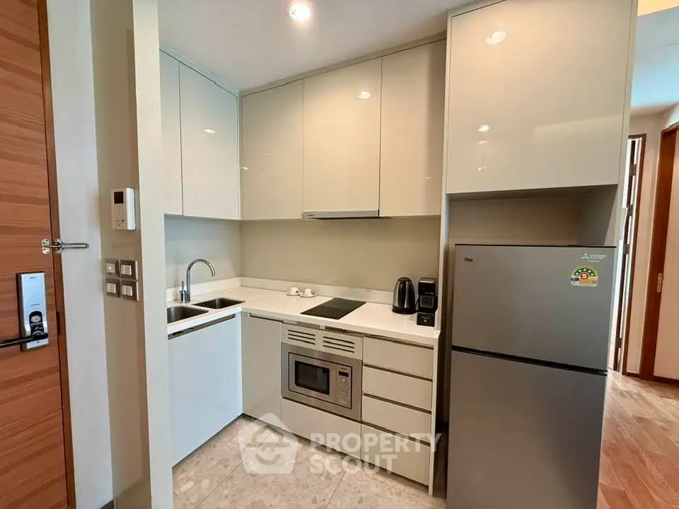 Modern compact kitchen with sleek cabinetry and stainless steel appliances