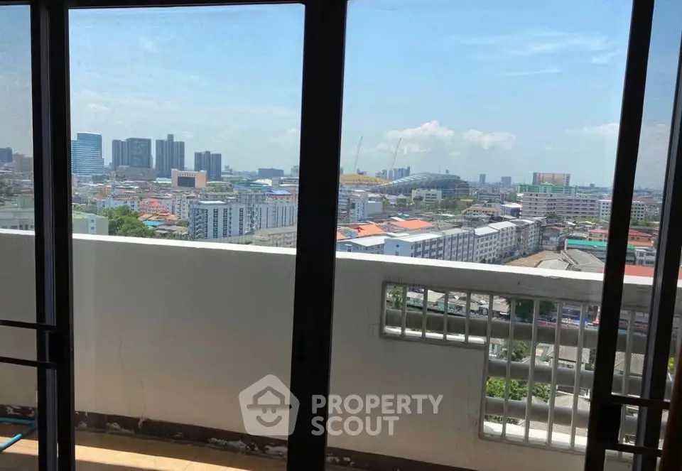 Stunning cityscape view from high-rise balcony with clear blue skies.