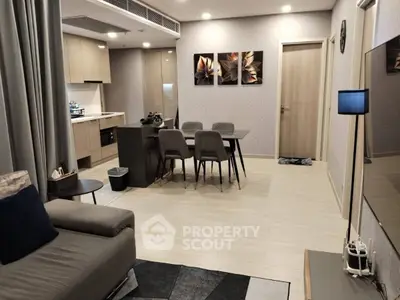 Modern open-plan living room and kitchen with stylish decor and dining area.
