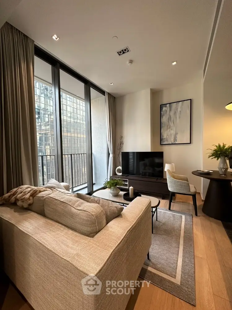 Elegant living room with natural light, modern furniture, and a cozy ambiance, featuring large windows and tasteful decor.