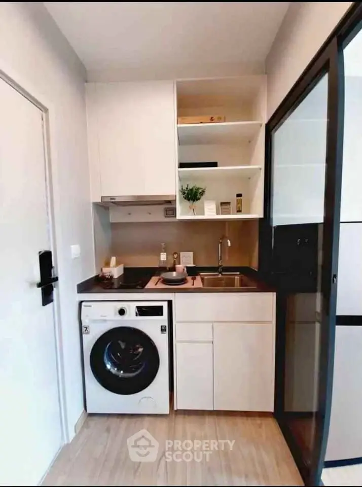 Compact modern kitchen with washing machine and sleek cabinetry