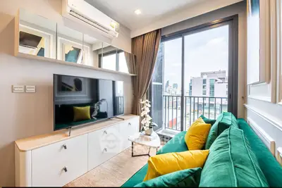 Modern living room with vibrant green sofa and city view balcony