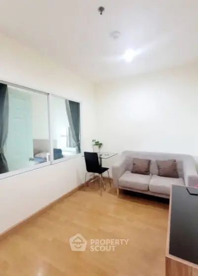 Cozy living room with modern sofa and glass table, perfect for relaxation and entertaining.