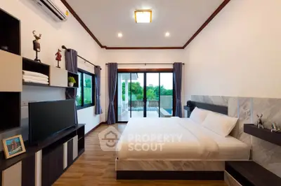 Spacious bedroom with modern decor and large windows overlooking a serene view, perfect for relaxation.