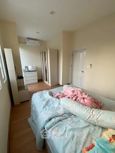 Cozy bedroom with stylish wardrobe and air conditioning in modern apartment.