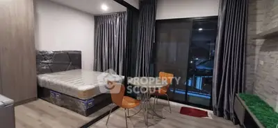 Modern studio apartment with cozy dining area and large windows for natural light.