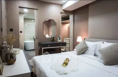 Luxurious bedroom with ensuite bathroom and elegant decor, featuring a cozy bed and stylish vanity.