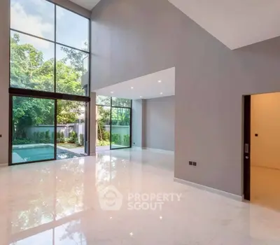 Spacious modern living room with large windows and garden view, perfect for natural light lovers.