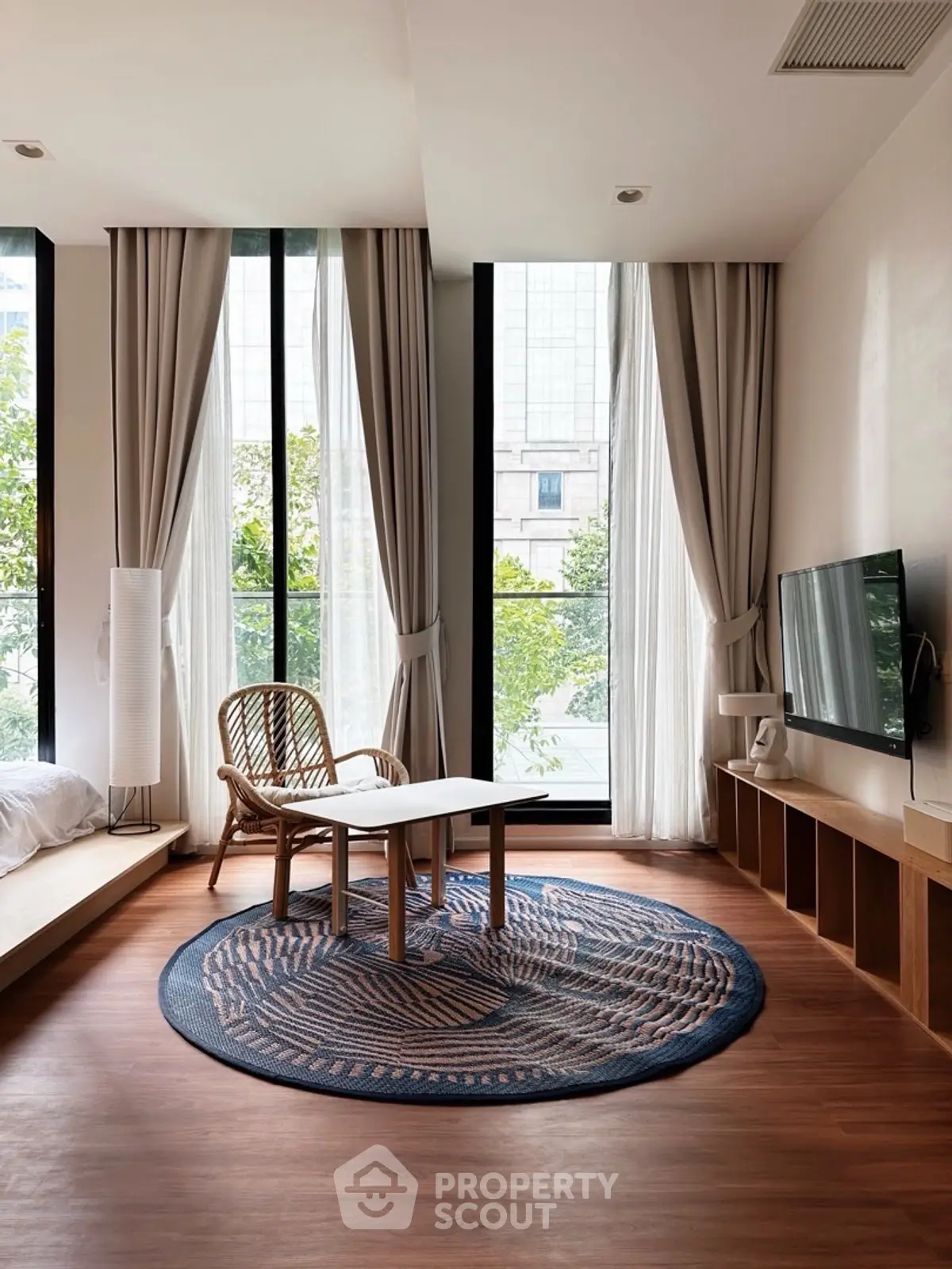 Modern living room with large windows, stylish furniture, and natural light in a contemporary apartment.