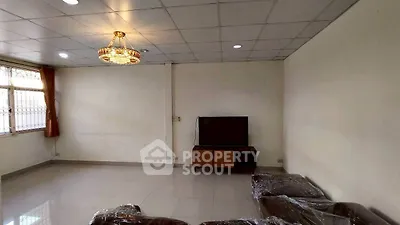 Spacious living room with modern chandelier and large window for natural light.