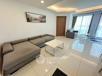 Spacious modern living room with elegant furniture and large windows offering natural light.