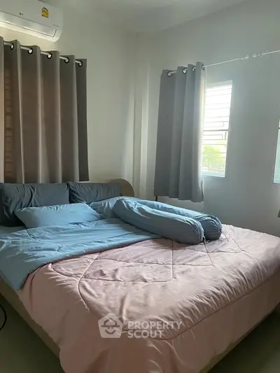 Cozy bedroom with natural light and modern decor, featuring a comfortable bed and stylish curtains.