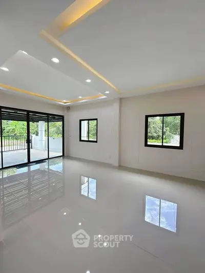 Spacious modern living room with large windows and glossy floors