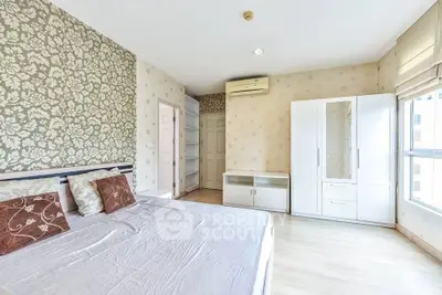 Spacious bedroom with elegant wallpaper and ample natural light