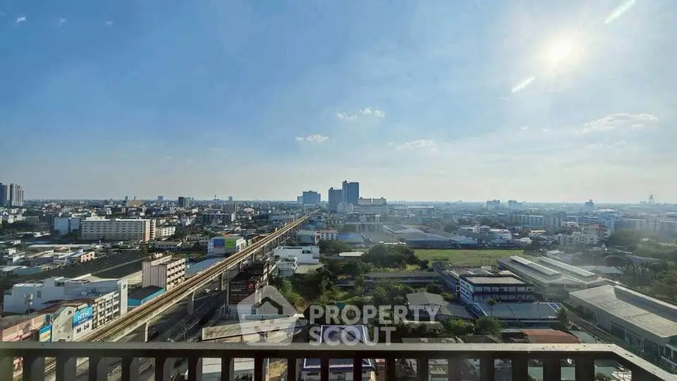Stunning cityscape view from a high-rise balcony showcasing urban skyline and clear blue sky.