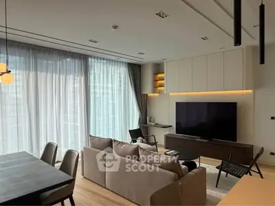 Modern living room with large windows, stylish furniture, and ambient lighting in a luxury apartment.