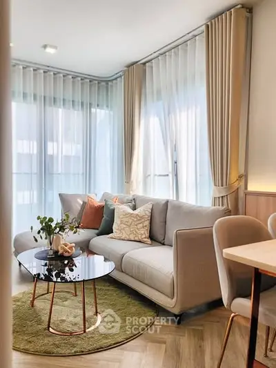 Stylish modern living room with elegant sofa, chic decor, and natural light through large windows.
