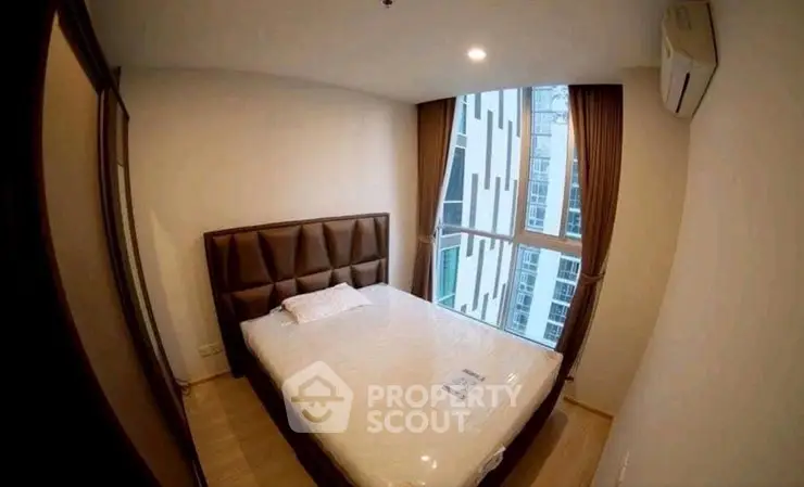 Cozy bedroom with large window and modern decor in urban apartment