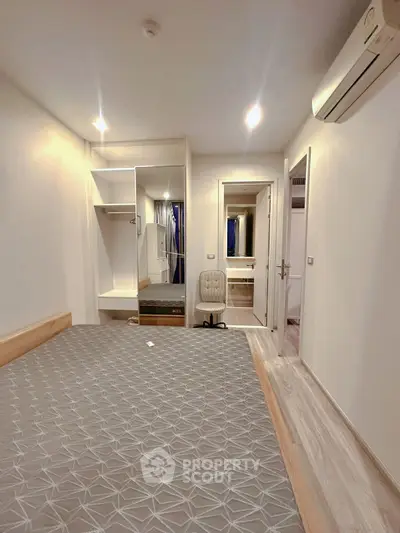 Modern bedroom with built-in wardrobe and air conditioning in a cozy apartment.