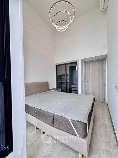 Modern bedroom with high ceiling and elegant lighting fixture