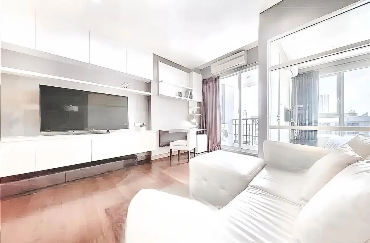 Bright and modern living room with large TV and balcony access