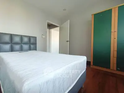 Spacious bedroom with modern bed and large wardrobe, perfect for comfortable living.