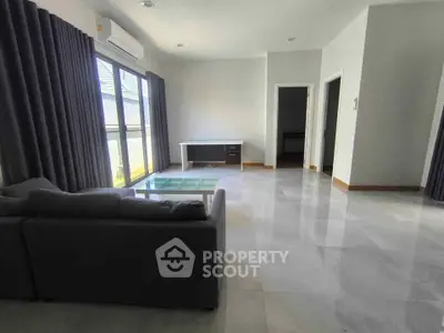 Spacious modern living room with large windows and sleek furnishings
