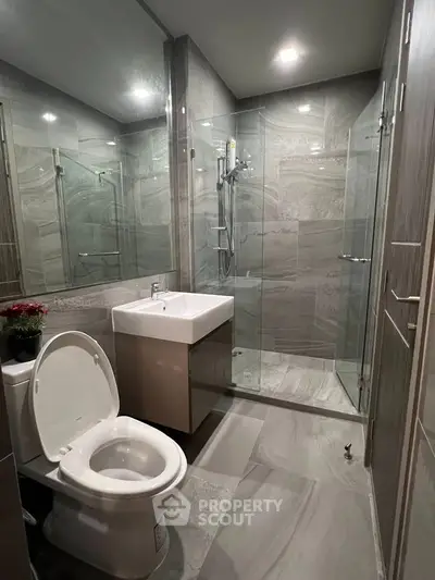 Modern bathroom with sleek design, glass shower, and elegant fixtures in a contemporary apartment.