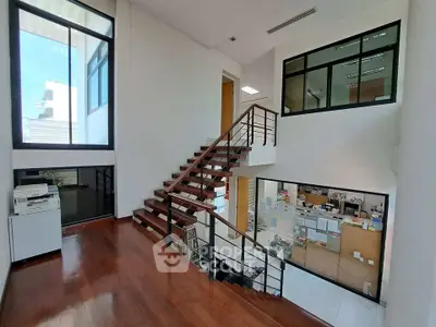 Modern office space with wooden staircase and large windows