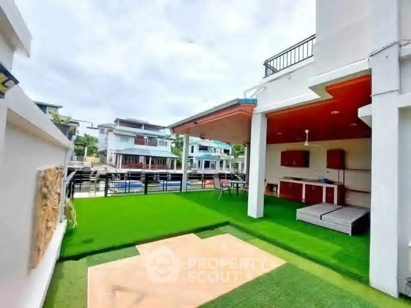 Spacious rooftop terrace with artificial grass and modern outdoor seating.