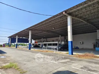 Spacious industrial warehouse with ample parking and covered loading area.