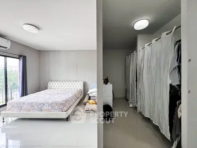 Spacious bedroom with walk-in closet and large windows offering natural light.