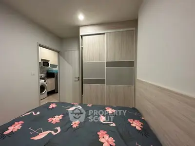 Cozy bedroom with modern closet and adjacent laundry area in stylish apartment.