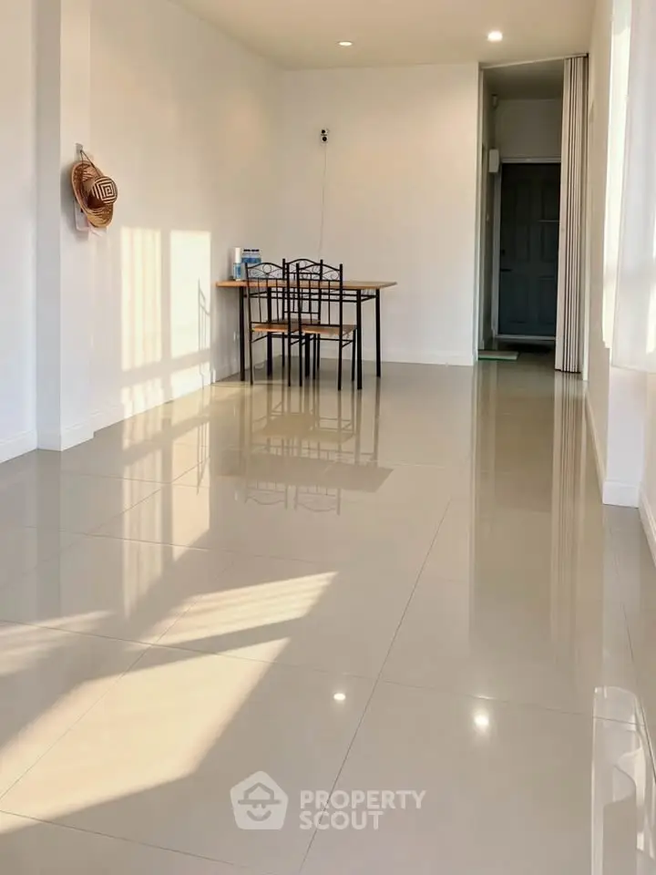 Spacious minimalist living room with glossy tile flooring and natural light