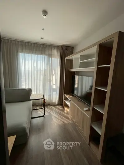 Cozy living room with modern furniture and large window for natural light.