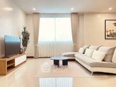 Modern living room with stylish sofa and large TV, bright and inviting space.
