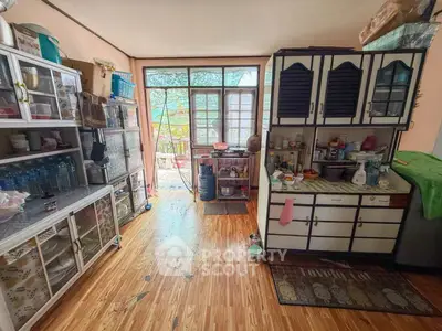 Charming kitchen with vintage cabinets and ample natural light, featuring a cozy open layout and wooden flooring.