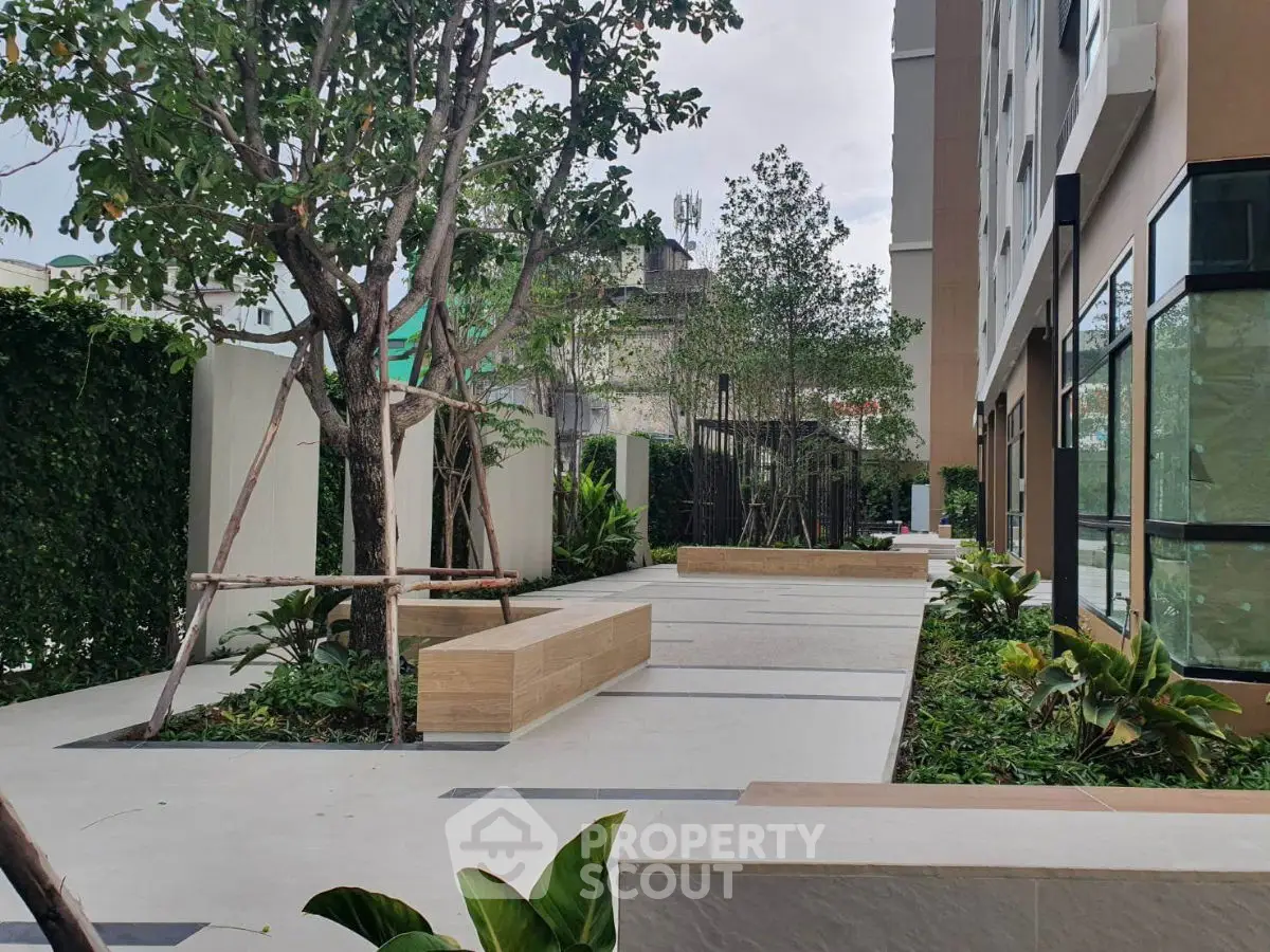 Modern apartment building with lush garden and seating area
