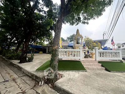 Charming outdoor area with lush greenery and traditional architectural features, perfect for serene living.
