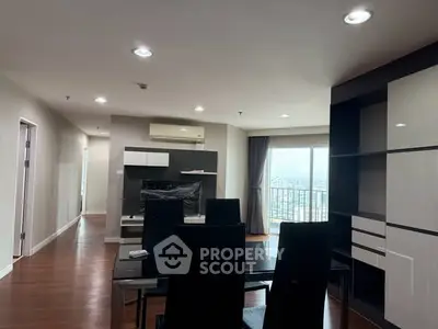 Spacious modern living room with sleek furniture and large windows offering stunning city views.