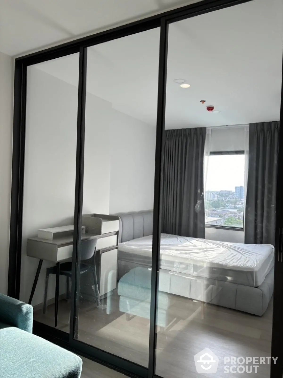 Modern bedroom with glass partition and city view in high-rise apartment