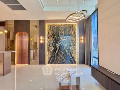 Luxurious modern living room with marble accent wall and elegant lighting fixtures.